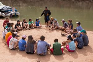 Grand Canyon Youth sitting in a circle next to the river connected