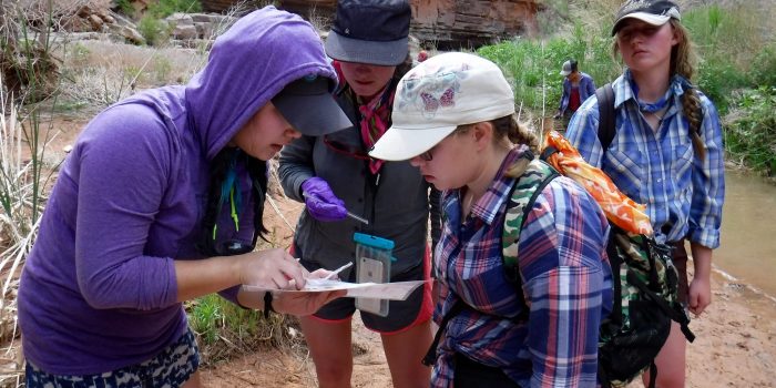 A scientist and Grand Canyon Youth participants take a closer look at a piece of paper